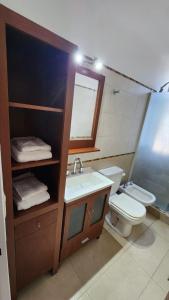 une salle de bain avec un lavabo, des toilettes et un miroir dans l'établissement Depto San Martín VCP, à Villa Carlos Paz