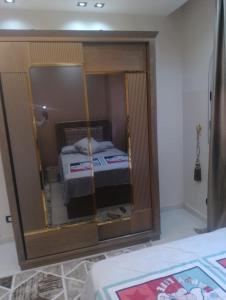 einen Spiegel in einem Schlafzimmer mit einem Bett darin in der Unterkunft Apartment in Madinaty Cozy in Madinaty + 7 Fotos