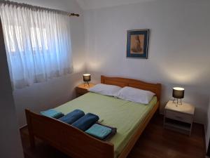 a bedroom with a bed with blue pillows on it at Holiday house Bore in Babino Polje