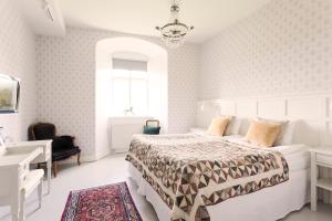 una camera da letto bianca con un letto e una scrivania di Bäckaskog Slott a Fjälkinge