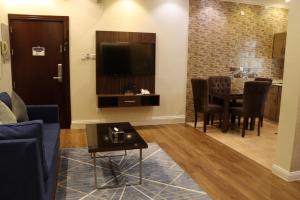 a living room with a table and a tv at القصر الضيافة 2 in Khamis Mushayt