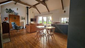 a kitchen and living room with a table and chairs at The Byre At Springbank in Kilrea