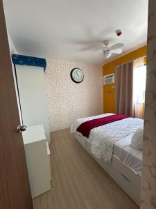 a bedroom with a bed and a clock on the wall at Tower C 3rd Floor in Taytay