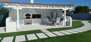 a white gazebo with a table in a yard at Guest House Mary in Porto Heli