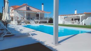 a villa with a swimming pool and a house at Guest House Mary in Porto Heli