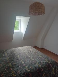 a bedroom with a bed and a window at Le gîte du Bonheur tranquille in Épégard