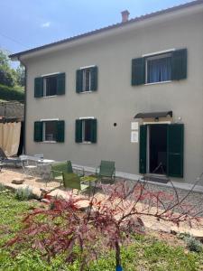 a house with green chairs in front of it at Nina s Casa di Langa in Rocca Ciglie