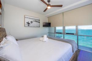 a bedroom with a white bed and a large window at Luxury Oceanview Escape in Nelly Bay