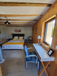 a bedroom with a bed and a desk in a room at la grange aux hirondelles in Sancoins