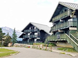 ein großes Gebäude mit Balkonen an der Seite in der Unterkunft Appartement Duplex 2P4 au Cœur des Chalets d'Aurouze à La Joue du Loup, Proche Commerces et Activités - FR-1-504-622 in Le Dévoluy