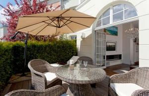 奥斯特西巴德钦诺维茨Villa Gruner App 5的带桌椅和遮阳伞的露台