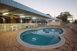a swimming pool with a pool table and chairs at Binalong Motel in Goondiwindi