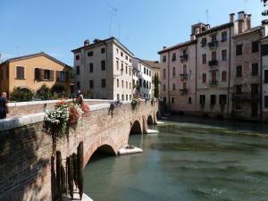 un ponte su un fiume in una città con edifici di B&B Al sogno di Laura a Treviso