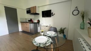 sala de estar con mesa de cristal y cocina en Studio Sydney Charme et jardin I séjour pro ou romantique, en Châtellerault 14 fotos más