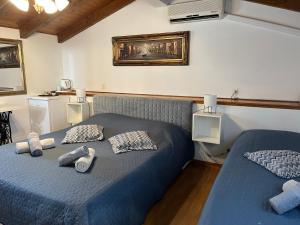 a bedroom with two beds with blue sheets and pillows at Rooms Barbieri Rovinj in Rovinj