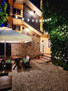 a patio with a table and an umbrella in front of a building at Casa Nicolas in Costinesti