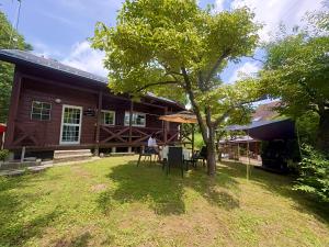 a house with a table and a tree in the yard at beau lac biwako annex in Takashima