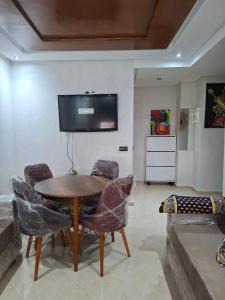 a living room with a table and chairs and a tv at Appartement centre-ville Dome in Kenitra