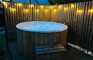 a hot tub with lights on a wooden fence at Pokoje i apartamenty Ferencówka Bieszczady in Zawóz