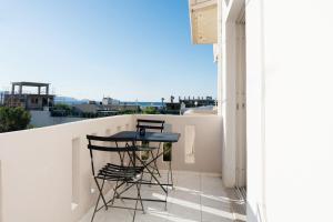 a table and chairs on a balcony with a view at Joseph Seaside Apartment 5 in Heraklio