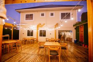 a restaurant with wooden tables and chairs and lights at Gold barbecue apartments in Tanga