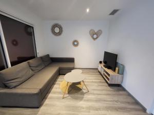 a living room with a couch and a table at Appartement cosy au calme in Hasparren