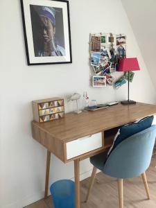 a wooden desk with a blue chair and a lamp at LES AUGUSTINS, chambres d'hôtes, quartier historique, accueil 2 roues in Angers