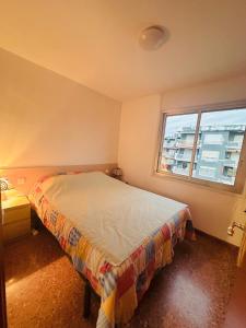 ein Schlafzimmer mit einem Bett und einem Fenster in der Unterkunft Beachfront apartment in Sant Salvador