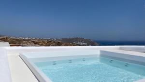 a white bath tub with blue water in it at Villa Aderfia with private hot tub in Ornos