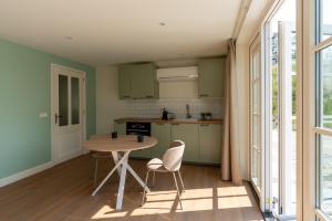 a kitchen with a table and chairs in a room at Appartement Het Brummelhof in Vrouwenpolder