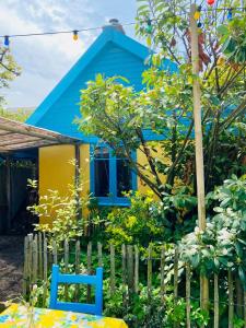 ein blau-gelbes Haus mit einem Stuhl davor in der Unterkunft Casa di Jardin in Bergen