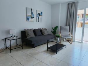 sala de estar con sofá negro y 2 mesas en Candelaria I, en Candelaria