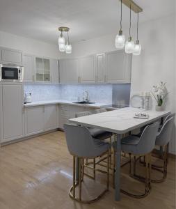 Una cocina con gabinetes blancos y una mesa y sillas. en Art&Heart - Centre historique, en Béziers