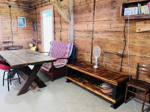 a wooden cabin with a table and a bench at Wioska Mnicha - Dom na końcu in Knyszyn