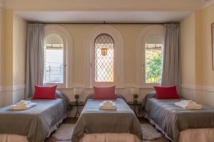 two beds in a room with two windows at Fliphaus Mansion Paz B - 10 pax Deluxe House Belgrano in Buenos Aires