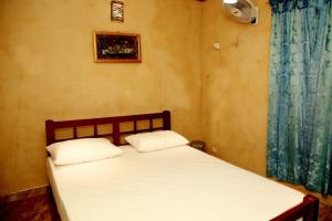 a bedroom with a bed with white sheets and a window at Breezy Haven Ella in Ella