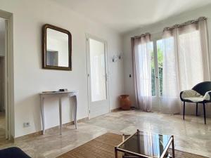a living room with a mirror and a glass table at Rez-de-villa dans le calme in Draguignan