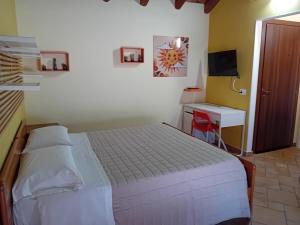 una camera da letto con un letto, una scrivania e una televisione di Casa Happy - La mansarda del sorriso con parcheggio privato a Valcorrente a Belpasso