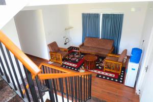 a living room with a couch and chairs and a table at Cheerful Chalet in Kodaikānāl