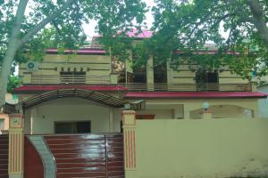 a house with a wooden gate and a fence at Golf View Lodges in Abbottabad