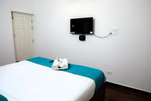 a bedroom with a bed with a tv on the wall at Cheerful Chalet in Kodaikānāl