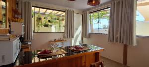 a kitchen with two tables and two windows at Studio Aconchego Correntina in Correntina