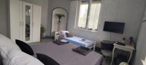 a living room with a couch and a table with chairs at Notre Doux Logis in Les Bordes
