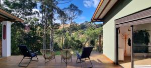 a group of chairs on a deck with a view at Recanto na Mantiqueira - Casa 3Q a 2 km do centro in Gonçalves