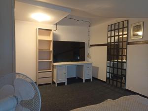 グダニスクにあるSeaside Amber Apartmentのデスク、テレビ、棚が備わる客室です。 +5枚の写真