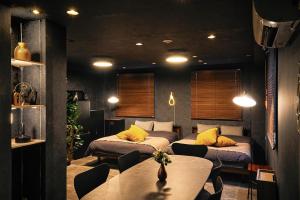 two beds in a room with a table and chairs at Hotel-Mercurius-Azabujuban-RB in Tokyo