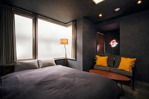 a bedroom with a bed and a chair and a window at Hotel-Mercurius-Azabujuban-RB in Tokyo