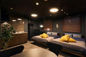 two beds with yellow pillows in a room at Hotel-Mercurius-Azabujuban-RB in Tokyo