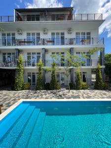 a hotel with a swimming pool in front of a building at Zatokas Sun Club in Zatoka