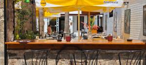 a wooden table with chairs and a yellow umbrella at Grand Erken Hotel in Antalya